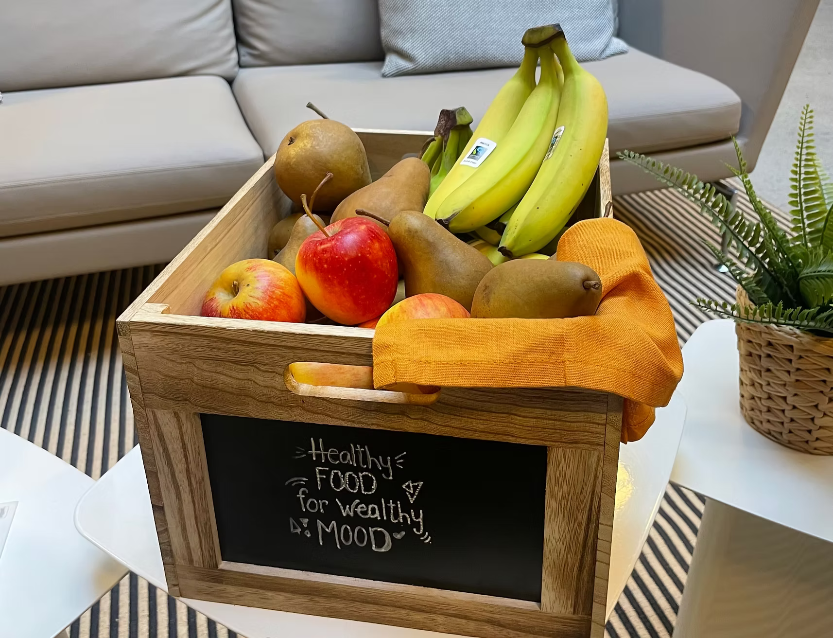 Frische Früchtebox mit Äpfeln, Birnen und Bananen im Büro